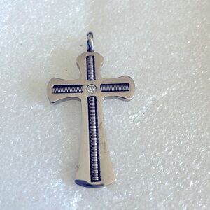 Stainless steel cross with small diamond chip in center.
